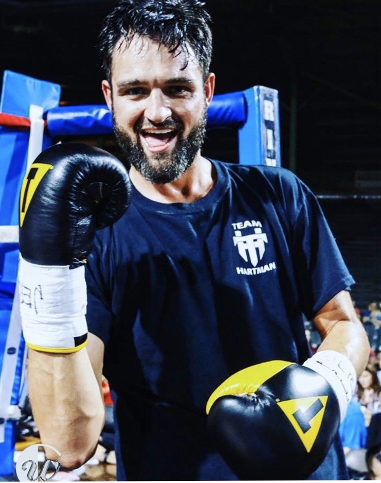 Travis Hartman in the boxing ring wearing gloves